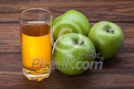 Glass of apple juice and apples on wooden background Glass of apple juice and apples on wooden background