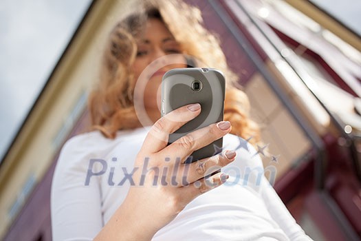 Woman using cellphone on the street. Outdoors image