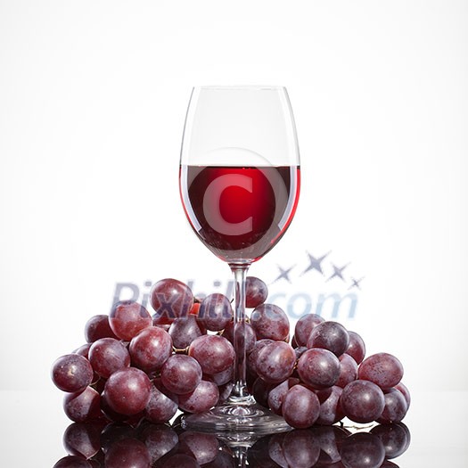 Glass of red wine and grape isolated on white background