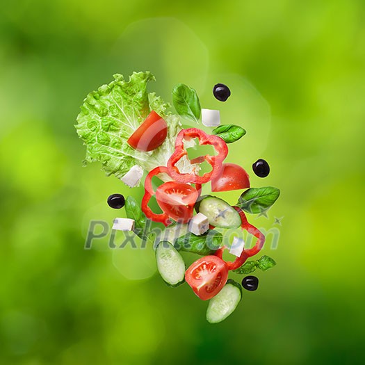 flying salad on natural green background - red tomatoes, pepper, cheese, basil, cucumber and olives flying salad on natural green background - red tomatoes, pepper, cheese, basil, cucumber and olives