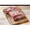 Photo of raw meat. Pork neck with herbs and green thyme on wooden board. Top view