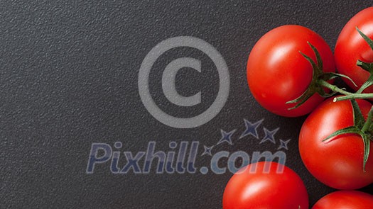 red tomatoes on black. Top view. Header for website