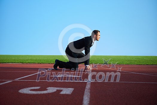 business man in start position ready to run and sprint on athletics racing track business man in start position ready to run and sprint on athletics racing track