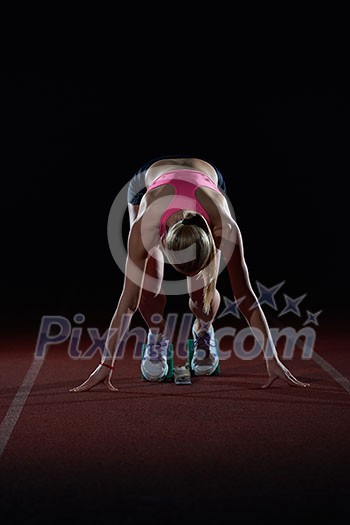 woman sprinter leaving starting blocks on the athletic track. Side view. exploding start woman sprinter leaving starting blocks on the athletic track. Side view. exploding start