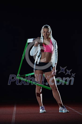 Determined young woman athlete jumping over a hurdles Determined young woman athlete jumping over a hurdles