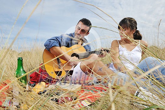 happy young couple enjoying  picnic on the countryside in the field  and have good time