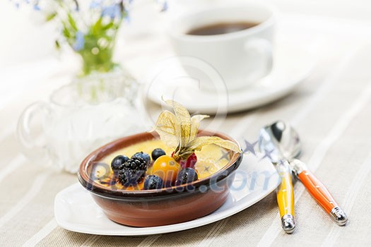 Sweet creme brulee dessert topped with fresh berries and coffee Sweet creme brulee dessert topped with fresh berries and coffee
