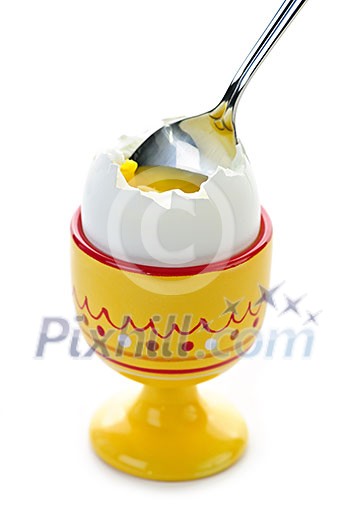 Closeup of soft boiled egg in cup with spoon on white background Closeup of soft boiled egg in cup with spoon on white background