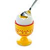 Closeup of soft boiled egg in cup with spoon on white background