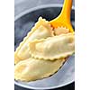 Cooked ravioli lifted from pot on spoon