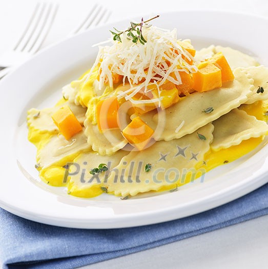 Gourmet squash ravioli dinner served with cheese on plate Gourmet squash ravioli dinner served with cheese on plate