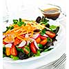 Plate of healthy green garden salad with fresh vegetables served with balsamic dressing