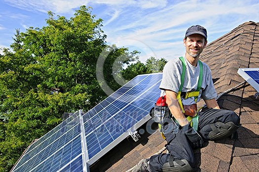 Man installing alternative energy photovoltaic solar panels on roof Man installing alternative energy photovoltaic solar panels on roof