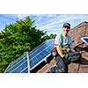 Man installing alternative energy photovoltaic solar panels on roof