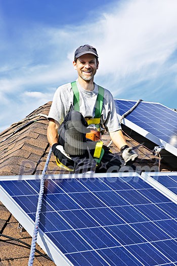 Man installing alternative energy photovoltaic solar panels on roof Man installing alternative energy photovoltaic solar panels on roof