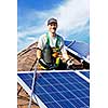 Man installing alternative energy photovoltaic solar panels on roof