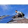 Man installing alternative energy photovoltaic solar panels on roof