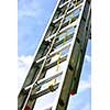 Closeup of construction aluminum extension ladder against blue sky