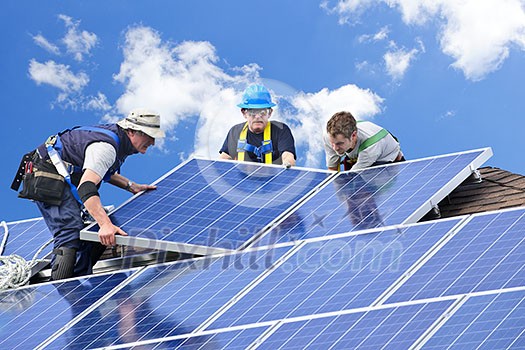 Workers installing alternative energy photovoltaic solar panels on roof Workers installing alternative energy photovoltaic solar panels on roof