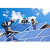 Workers installing alternative energy photovoltaic solar panels on roof