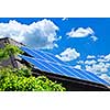 Array of alternative energy photovoltaic solar panels on roof of residential house