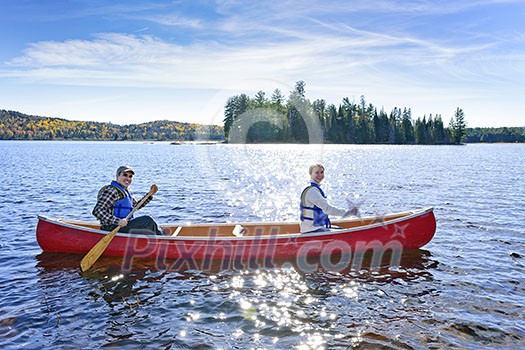 Family canoeing on sunny Lake of Two Rivers, Ontario, Canada Family canoeing on sunny Lake of Two Rivers, Ontario, Canada