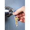 Hand inserting keys in door lock close up