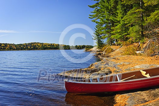Red canoe on rocky shore of Lake of Two Rivers, Ontario, Canada Red canoe on rocky shore of Lake of Two Rivers, Ontario, Canada