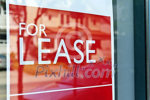 For Lease sign on red in window reflecting street scene For Lease sign on red in window reflecting street scene