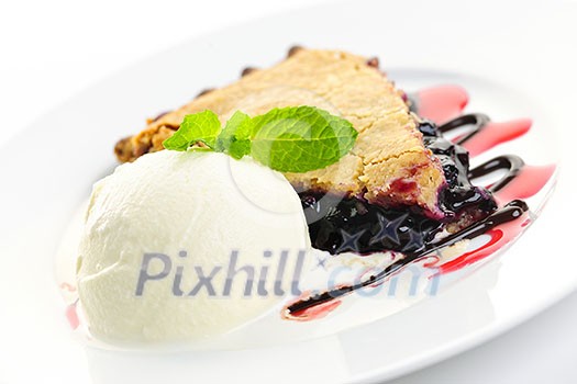Slice of blueberry pie and vanilla ice cream served with dessert sauces