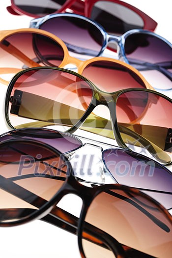 Assorted styles of tinted sunglasses on white background close up