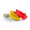 Three colorful measuring tapes coiled on white background