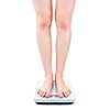 Slender female legs standing on bathroom scale