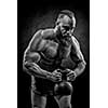 Bodybuilder with a beard lifts a heavy kettlebell. Black and white portrait of a strongman.