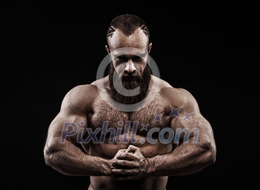 Strong man with perfect abs, shoulders, biceps, triceps and chest. Bodybuilder topless over black background.