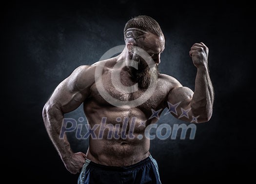 Strong man with perfect abs, shoulders, biceps, triceps and chest. Bodybuilder topless over grunge background.