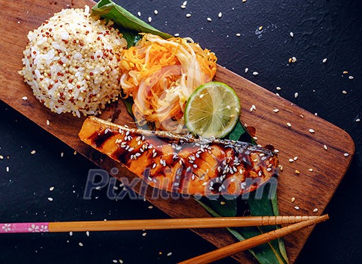 Teriyaki salmon with rice on a wooden platter. Top view. Teriyaki salmon with rice on a wooden platter. Top view.