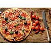 Delicious fresh pizza with mushrooms, cherry and pepperoni served on wooden table