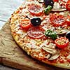 Delicious fresh pizza with mushrooms, cherry and pepperoni served on wooden table