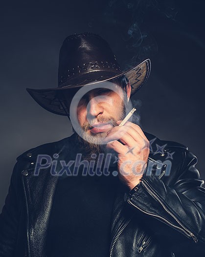 Smoking man with a beard and mustache wearing a cowboy hat. Hipster colors. Smoking man with a beard and mustache wearing a cowboy hat. Hipster colors.