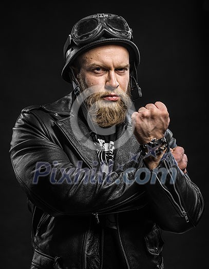 Angry Bearded Biker Man in Leather Jacket and Helmet over Black Background Angry Bearded Biker Man in Leather Jacket and Helmet over Black Background