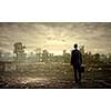 Rear view of businessman looking at ruins of city