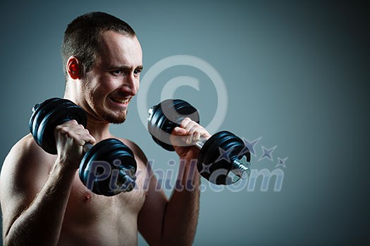 Close up of young man lifting weights over grey background (color toned image) Close up of young man lifting weights over grey background (color toned image)