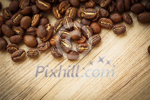 Coffee beans on a wooden desk lit by warm light (shallow DOF; color toned image) Coffee beans on a wooden desk lit by warm light (shallow DOF; color toned image)