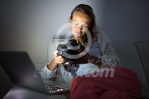 Very tired young woman, burning the midnigh oil - working late at night on her laptop computer, at home, sitting on sofa, rubbing her tired eyes, trying to stay focused