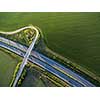 Aerial view of a highway amid fields with cars on it