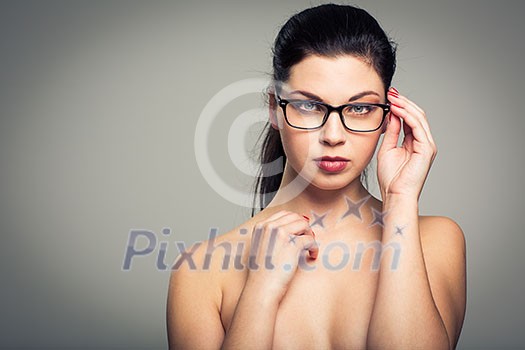 Portrait of a smiling pretty, young woman wearing glasses with copy space - studio shot, color toned