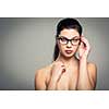 Portrait of a smiling pretty, young woman wearing glasses with copy space - studio shot, color toned