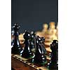 Close up of black chess pieces on wooden chessboard