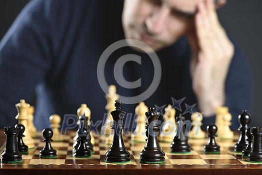 Chessboard with man thinking about chess strategy Chessboard with man thinking about chess strategy